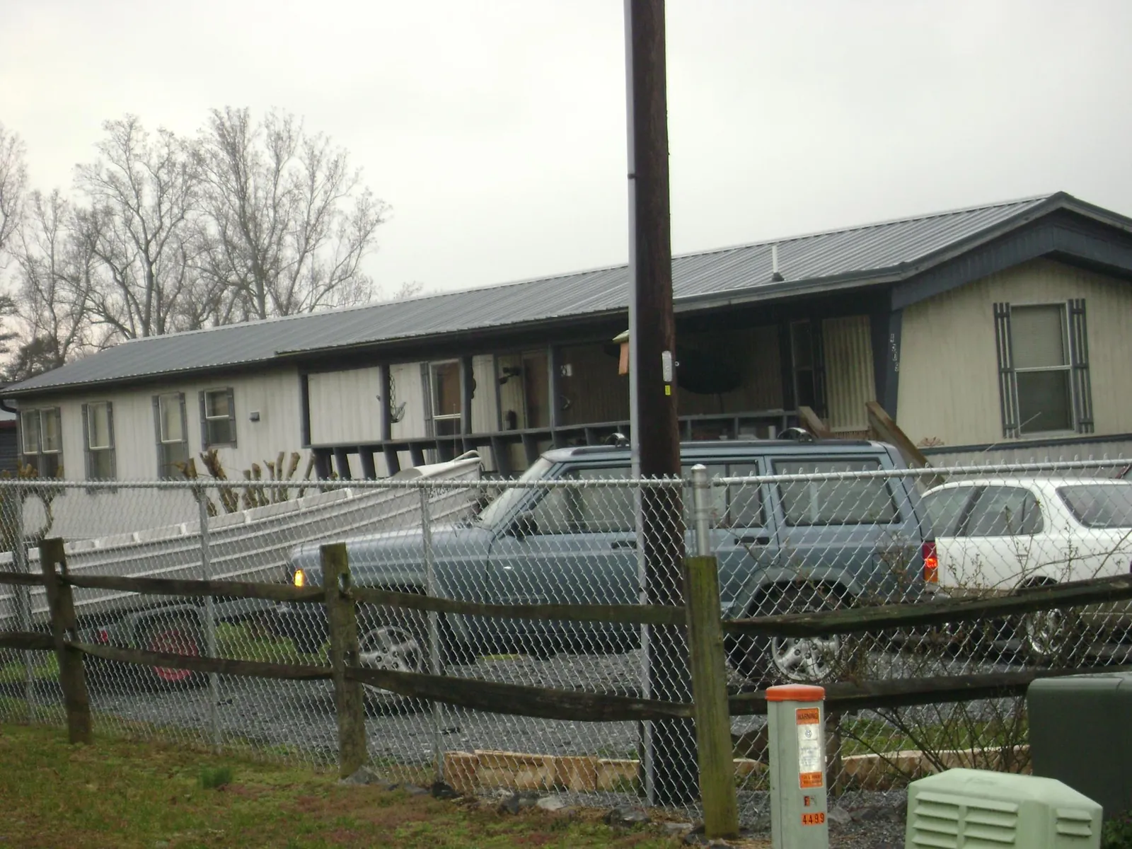 Dark metal roof on a long single story building behind a chain link fence in Tokeland